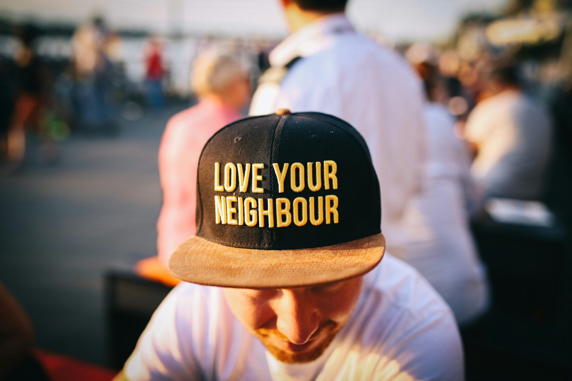 Person with a hat that reads "Love your neighbor"