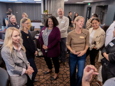 People standing in a room chatting.